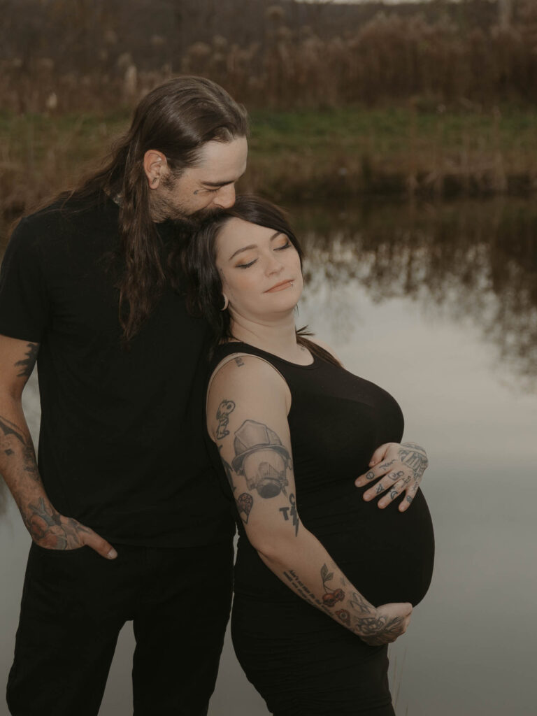 A moment where two soon-to-be parents take a moment to reflect on the excitement in anticipation of their first born. They sit at the edge of the pond, the mother embracing her belly and leaning into her partner while he gently kisses her head.